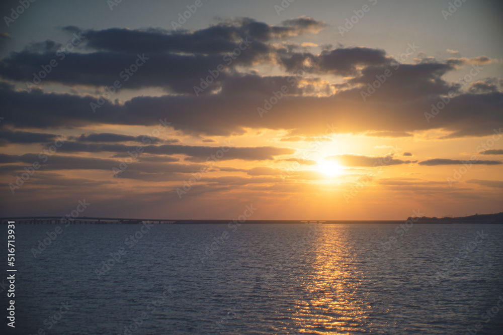 Obraz premium 沖縄の離島 宮古島の美しい夕焼け 夕日に照らされた海と空の風景