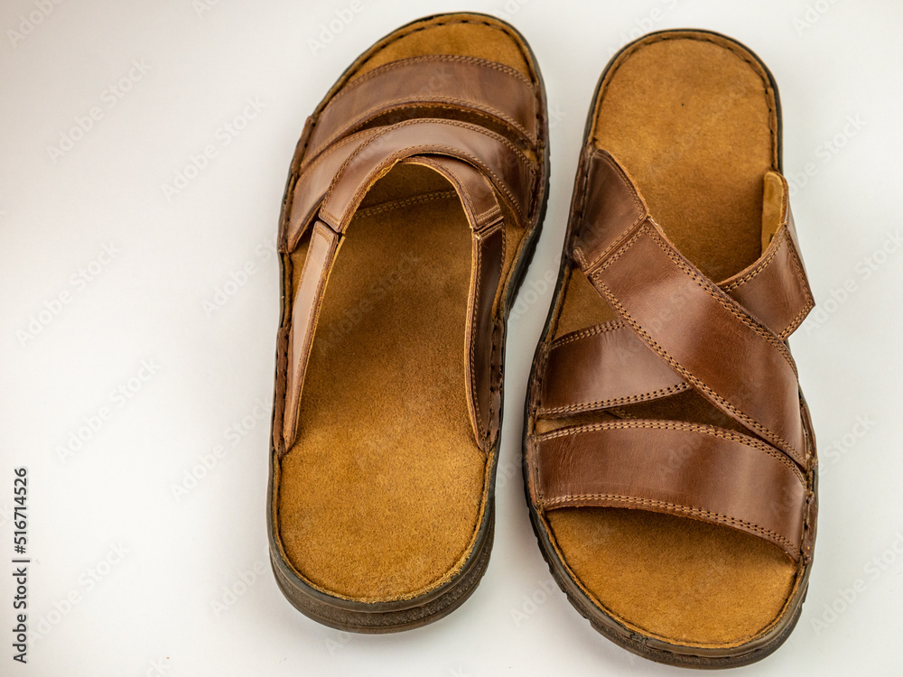 Men's sandals are brown leather flip-flops on a white background. Men's sandals are brown leather flip-flops on a white background.