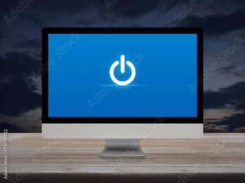 Power button icon on desktop modern computer monitor screen on wooden table over sunset sky, Business start up online concept