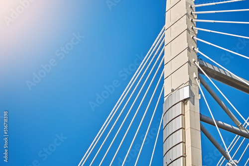 Ropes of a cable-stayed bridge against a blue sky