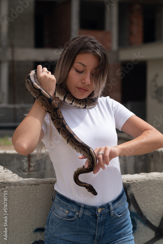 Woman portrait holding a snake in an urban environment
