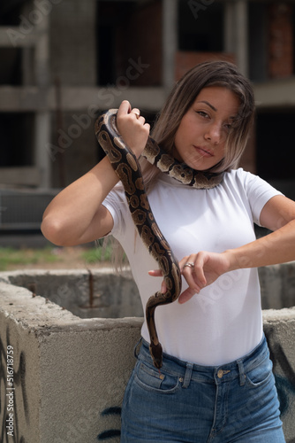 Woman portrait holding a snake in an urban environment