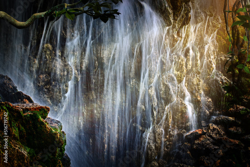 A large waterfall in the sun's rays tropical mysterious fairy jungle
