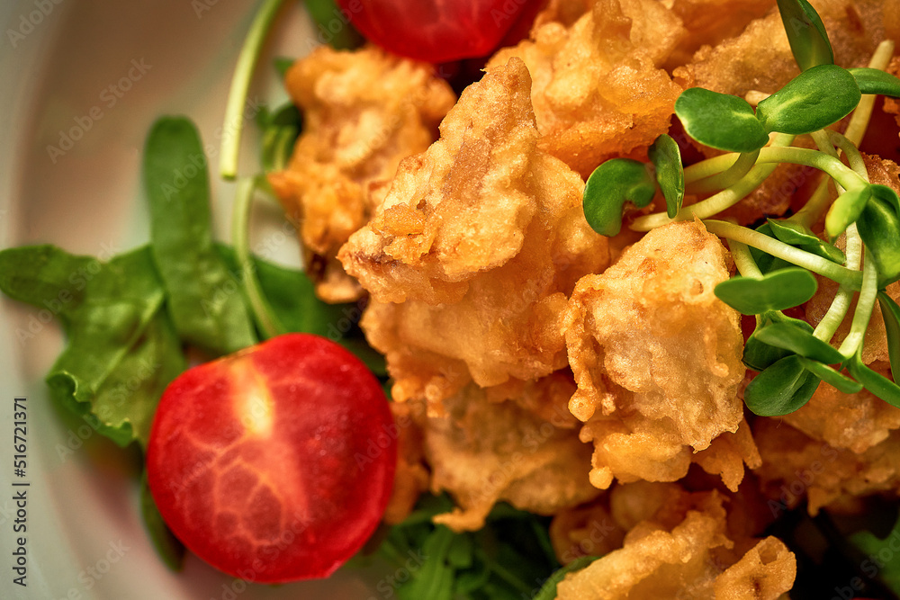 Fish in batter fried in oil with sauce. Close-up. Selective focus. Noise in post-production