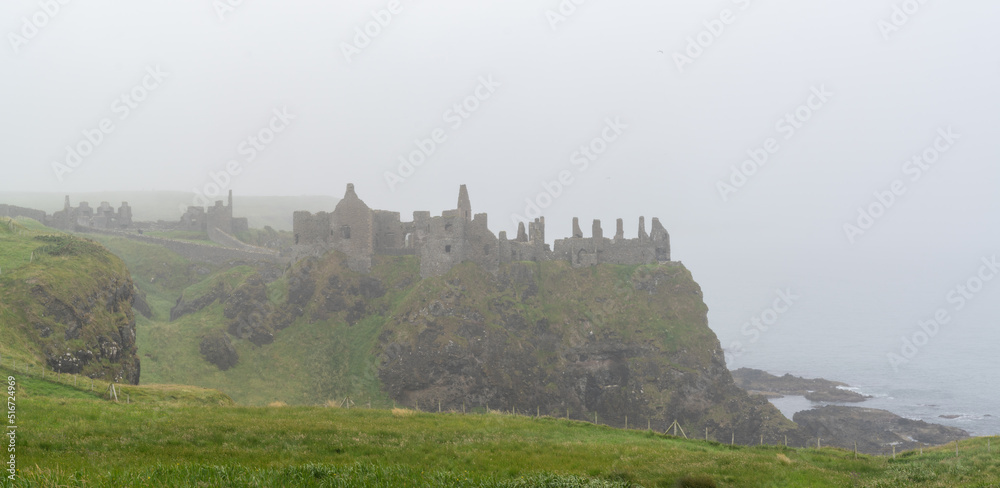 panorama view of the ruins of Dunluce Castle on a foogy day on the north coast of Ireland