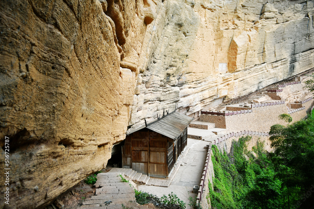 Fototapeta premium ancient wooden houses under rocky cliffs in the mountains