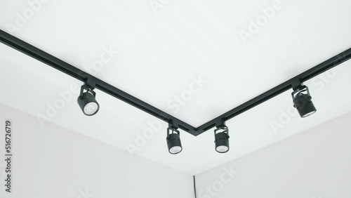 Track lighting in a room with white walls and ceiling. LED lightening
 photo
