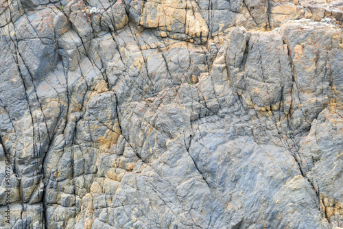 some weathered eroded cracked rocks on the coastline