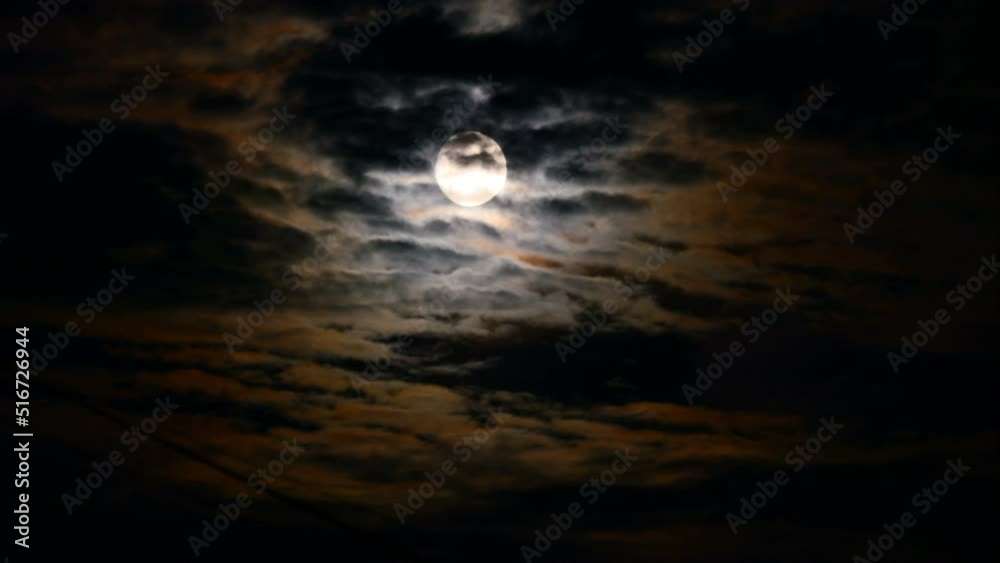 Moon time lapse across cloudy sky