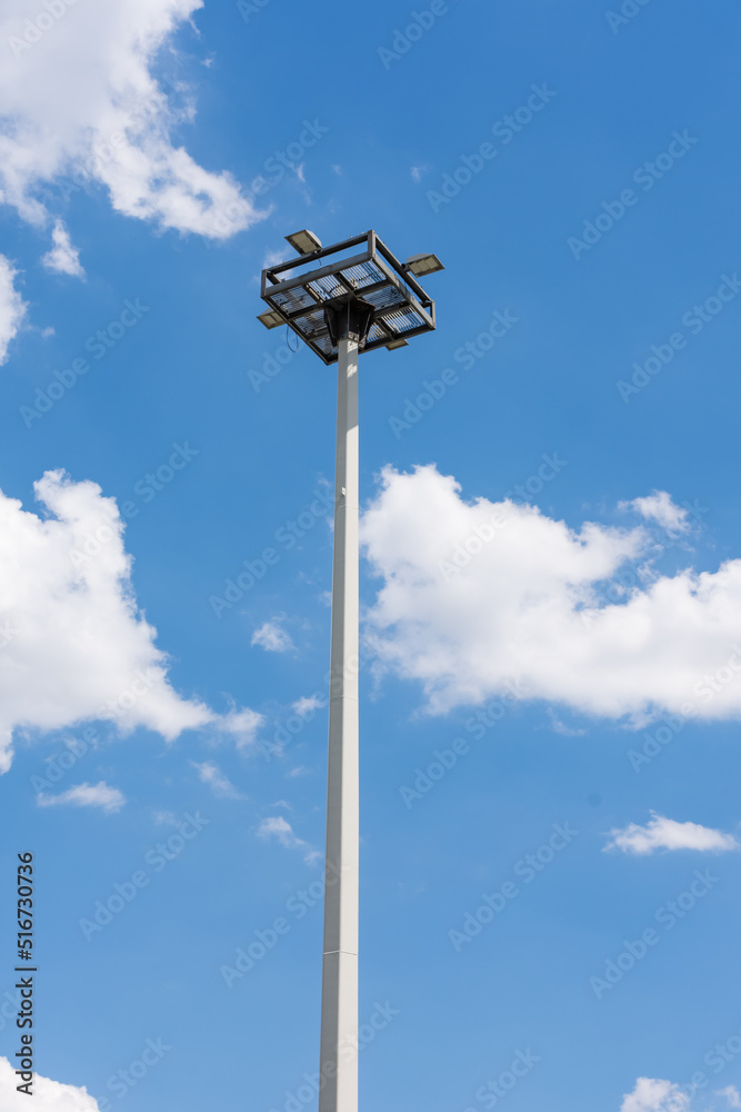 a floodlight with blue sky and clouds