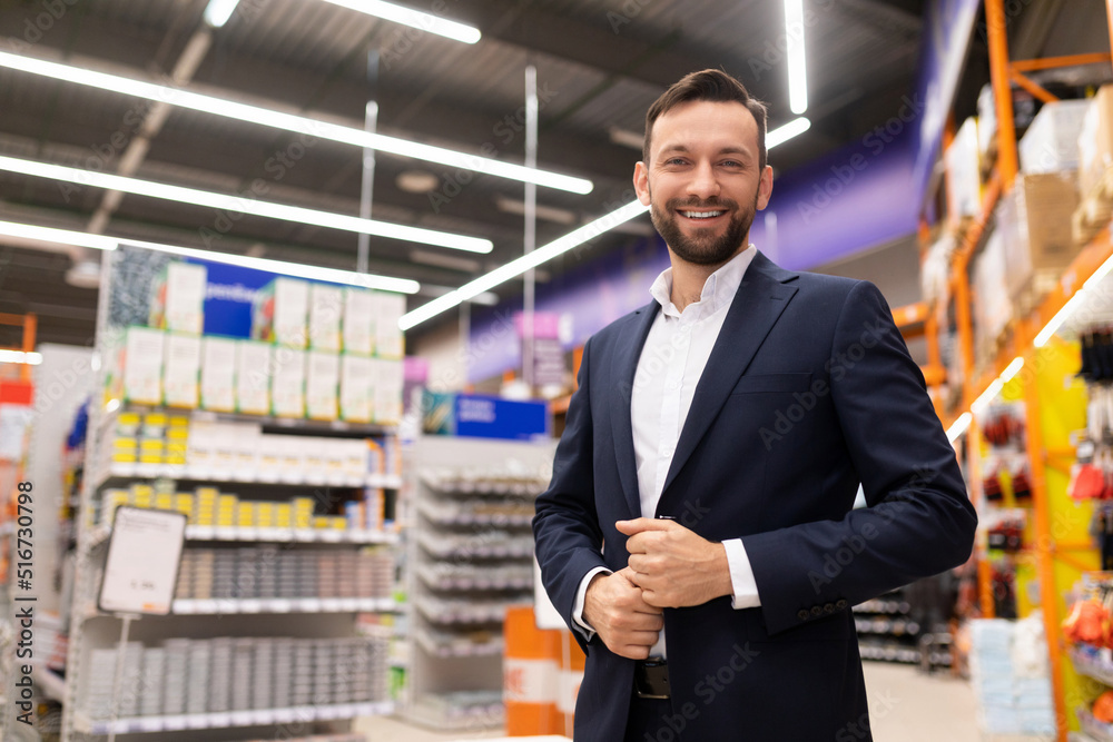 friendly manager of a hardware store in a business suit looking at the camera with a smile