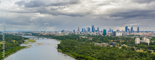 Moody sky over distant skyline of Warsaw city center and Vistula river aerial landscape