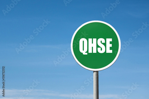 'QHSE' sign in green round frame. Blue sky is on background