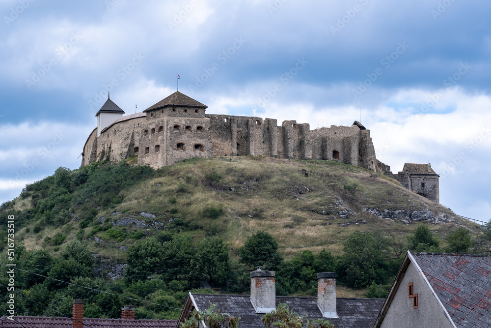 View of Castle of Sümeg on a hill with chimneys in the foreground in Hungary