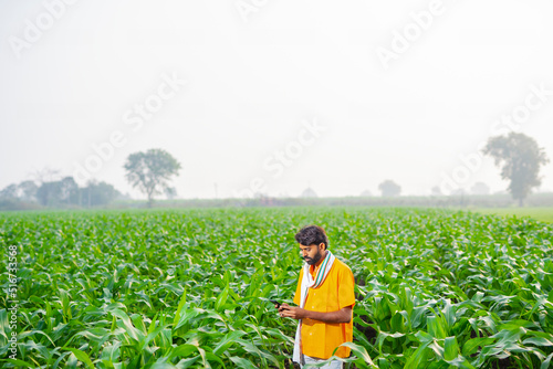 young indian farmer using a smart phone