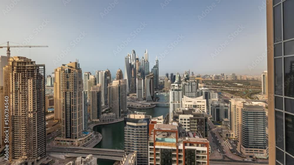 View of various skyscrapers in tallest recidential block in Dubai Marina aerial timelapse with artificial canal. Many glass towers and yachts