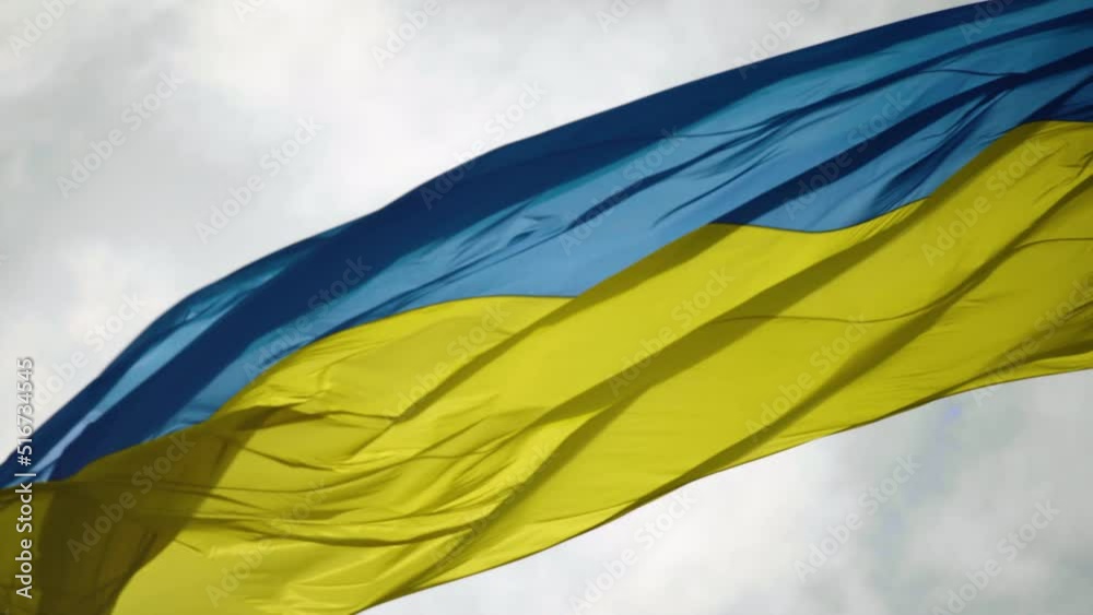 The flag of Ukraine flutters against the background of the sky. The flag moves diagonally in waves. Close-up The flag of Ukraine flutters against the background of the sky. The flag moves diagonally in waves. Close-up