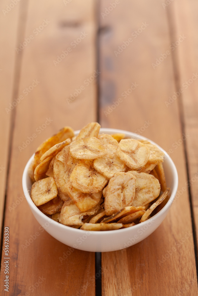 Close-up of Crunchy salty banana chips in white bowl, made fried banana, Indian salty snacks (Namkeen), Close-up of Crunchy salty banana chips in white bowl, made fried banana, Indian salty snacks (Namkeen),