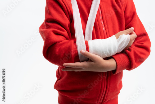 Little boy with broken arm in a cast after injury. Arm splint for treatment and quick recovery.