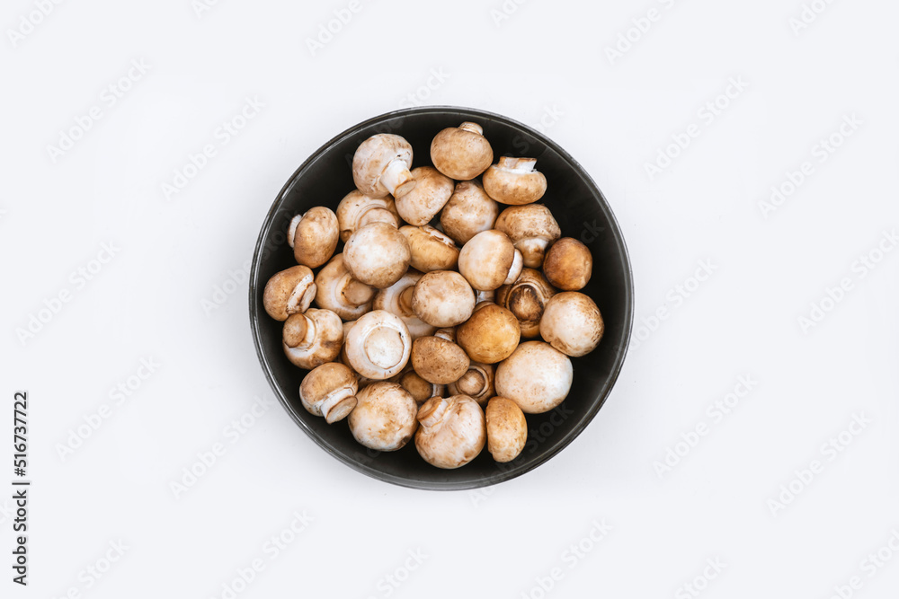 top view of fresh mushrooms in bowl on white background. Copy space. top view of fresh mushrooms in bowl on white background. Copy space.