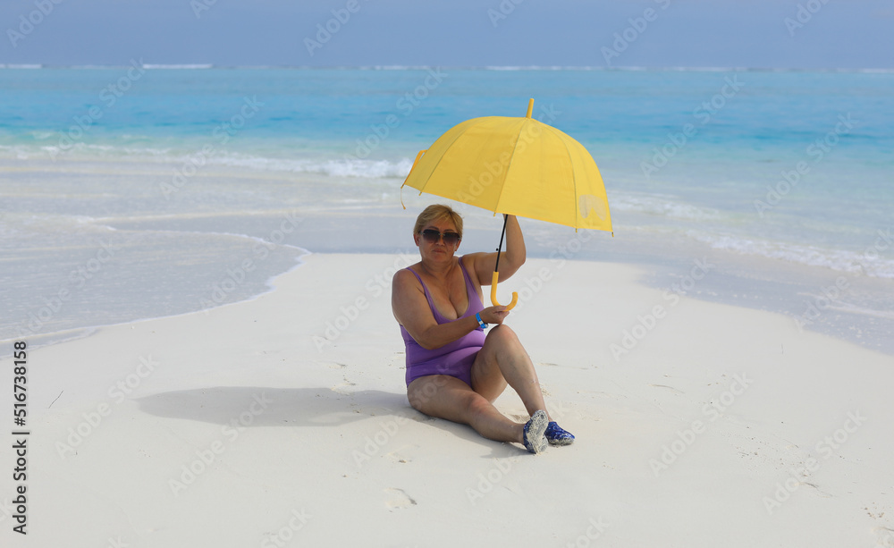 old bikini woman with umbrella on sea sand old bikini woman with umbrella on sea sand