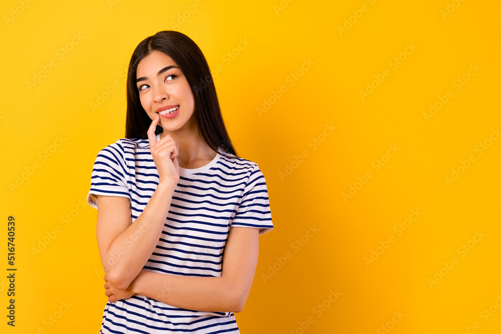 Photo of pretty thoughtful girl dressed striped clothes finger mouth looking empty space isolated yellow color background Photo of pretty thoughtful girl dressed striped clothes finger mouth looking empty space isolated yellow color background