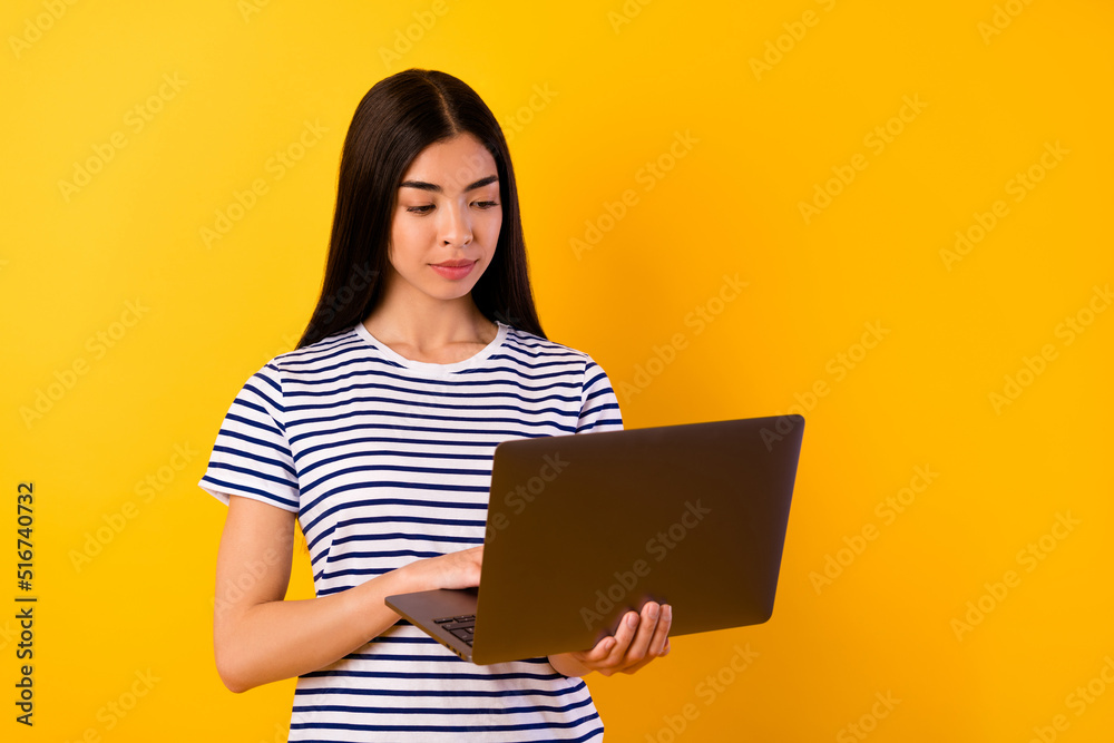 Portrait of nice pretty vietnamese lady use wireless netbook coworking isolated on yellow color background Portrait of nice pretty vietnamese lady use wireless netbook coworking isolated on yellow color background