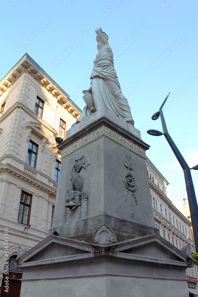 Fototapeta premium The ancient Nereids fountain on the Ferenciek square in the old town of Budapest, Hungary, Eastern Europe. Nymphs, one with a jar on top of her head, beautiful mythological stone figures.