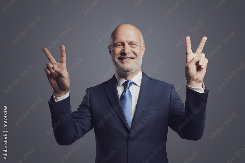 Cheerful businessman making a V sign