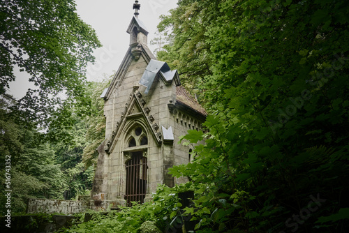 Abandoned cemetery chapel in a dense green forest