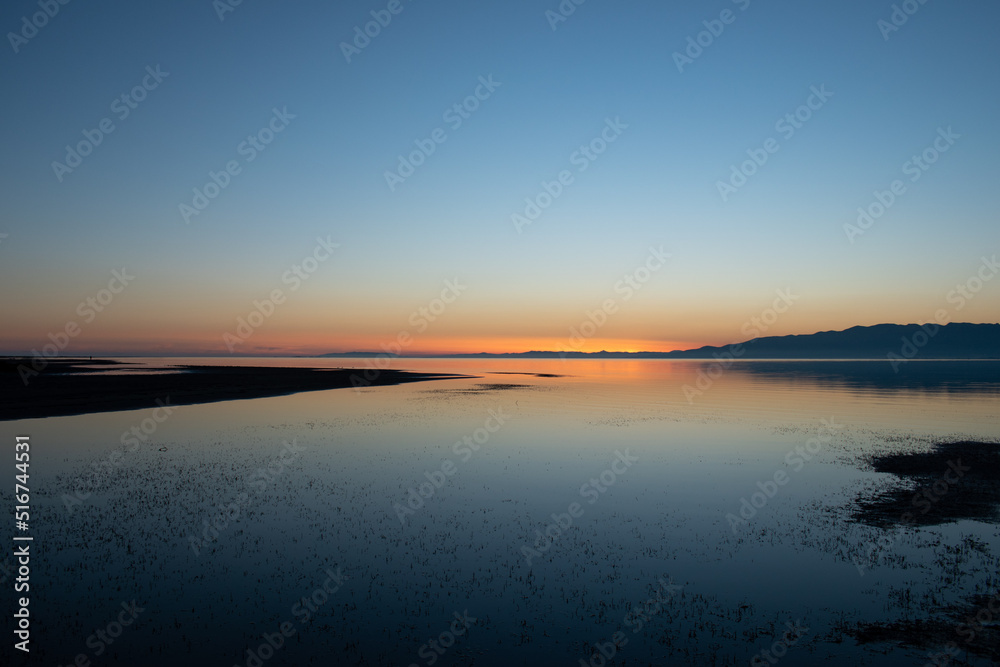 After the sunset on the sea with reflections of on the calm water