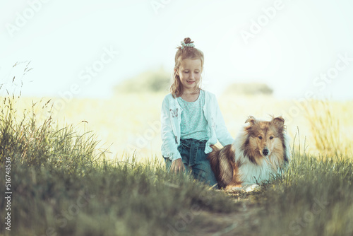 Junges blondes Mädchen mit schottischem Collie sable white im Sommer zusammen auf einer Wiese outdoor Var. 2 photo