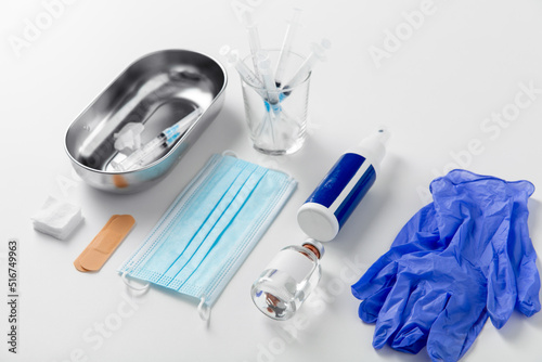 medicine and healthcare concept - close up of syringes, gloves, mask and other medical stuff on table at hospital