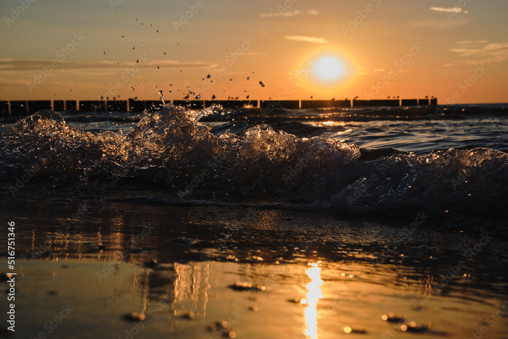 Rough Baltic Sea with large waves on the beach during a warm sunset