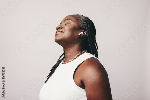 Canvas-taulu Carefree woman with dreadlocks listening to music in a studio
