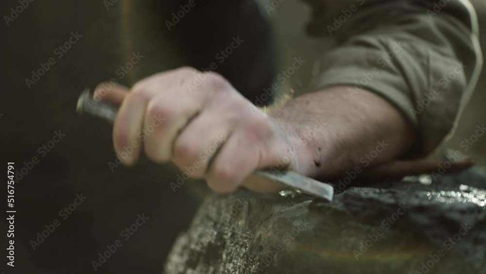 Sculptor shaping a big stone. Rock breaking. Stone carving. Changing tools.