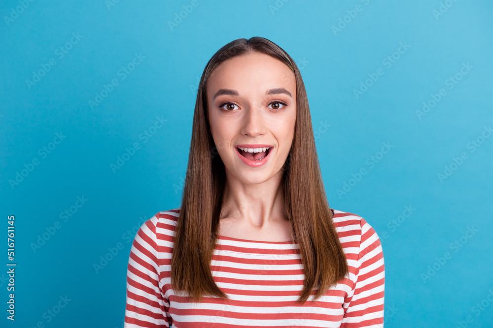 Surprised happy beautiful woman looking in camera with excitement. Isolated on blue color background Surprised happy beautiful woman looking in camera with excitement. Isolated on blue color background
