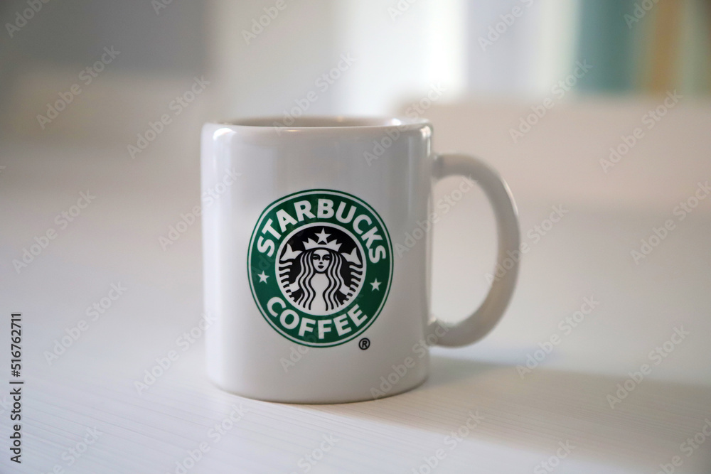 Foto Stock Starbucks Coffee. Cup of coffee from the famous chain of fast  coffee shops in the United States. White ceramic mug with the Starbucks  logo. Coffee business. Franchise. Corporation. Hot drinks