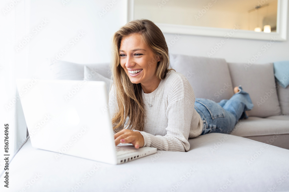 Communication is very important. Top view portrait of young smiling woman sitting on sofa at home with laptop laying on back-rest. Business woman working from home Communication is very important. Top view portrait of young smiling woman sitting on sofa at home with laptop laying on back-rest. Business woman working from home