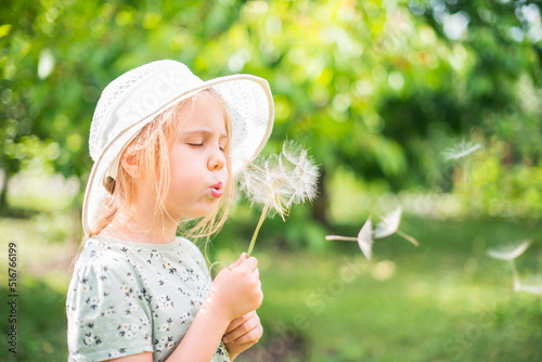 Child girl blow dandelion flower on outdoors. Soul harmony and freedom concept.