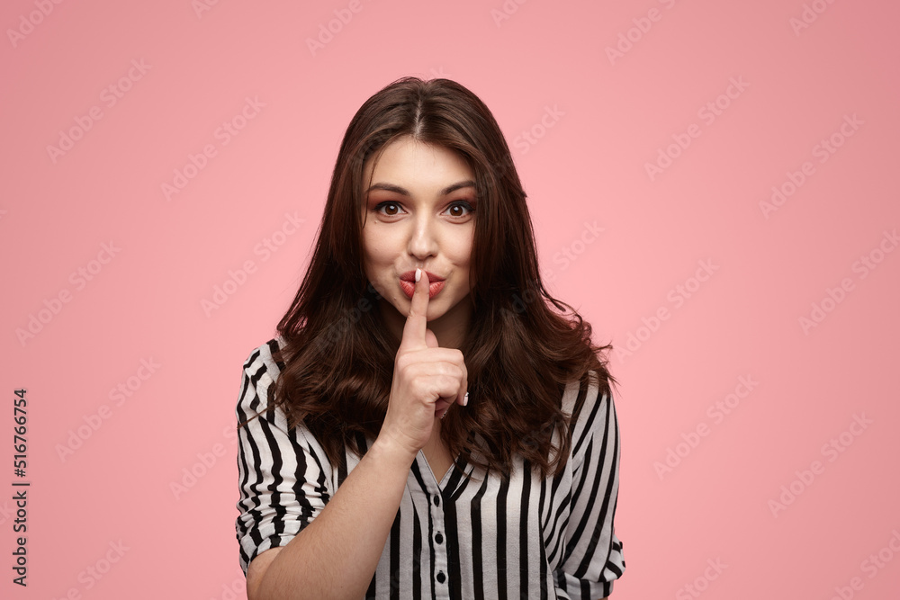 Naklejka premium Young brunette showing shh gesture
