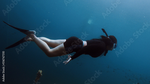 Person snorkeling in the sea. Woman freediving in open water.