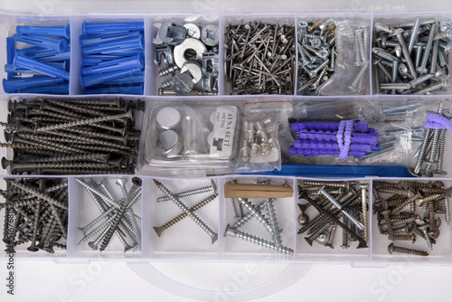 A set with small construction items in a box. Tool box with nails, screws, bolts, anchors, plugs, screws.