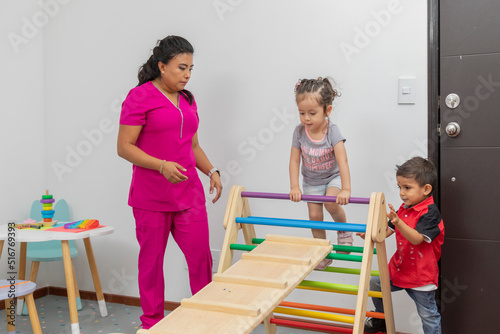 Female doctor giving consultation to two children in the games room of her office