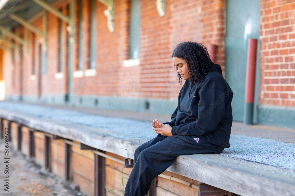 solitary girl sitting alone on disused station platform solitary girl sitting alone on disused station platform