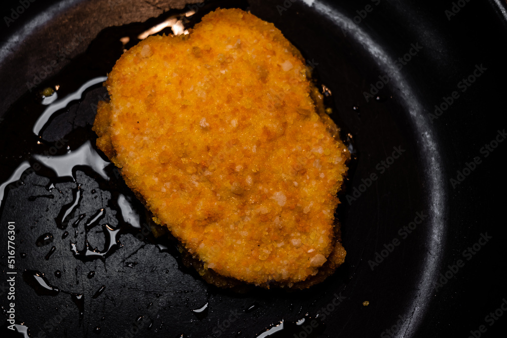 top view of cordon bleu in a frying pan. breaded chicken cooking. close up of frying pan with oil and meat top view of cordon bleu in a frying pan. breaded chicken cooking. close up of frying pan with oil and meat