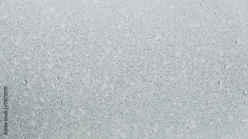 Transparent water droplets on a glass background