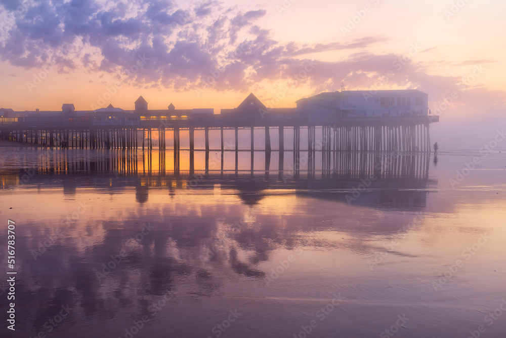 Pier in fog at dawn. A famous place on the coast of the Atlantic Ocean. Old pier. USA. Maine. Old Orchard Beach.