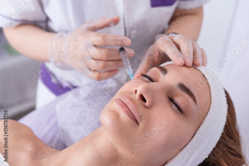 portrait of a young woman receiving facial mesotherapy treatment to smooth wrinkles. an anti-aging injection to firm up the skin