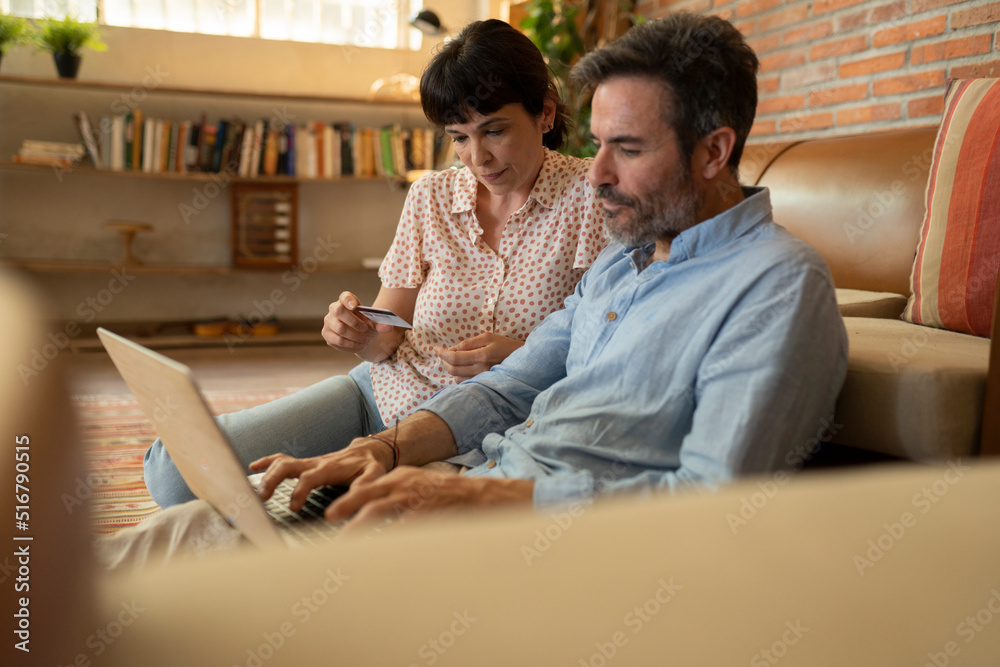 Obraz premium mature couple shopping online with credit card from home
